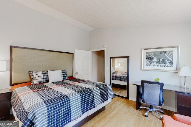 bedroom featuring vaulted ceiling and light wood-type flooring