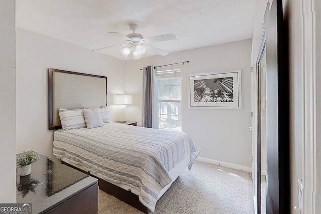 bedroom with light carpet, ceiling fan, and baseboards