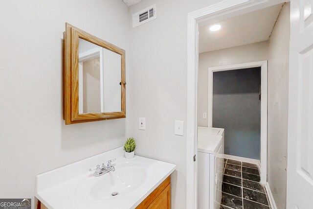 bathroom featuring washer / clothes dryer, visible vents, and vanity