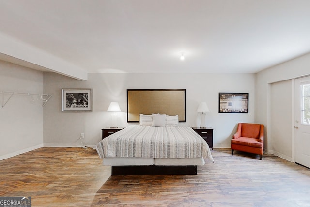 bedroom with baseboards and wood finished floors