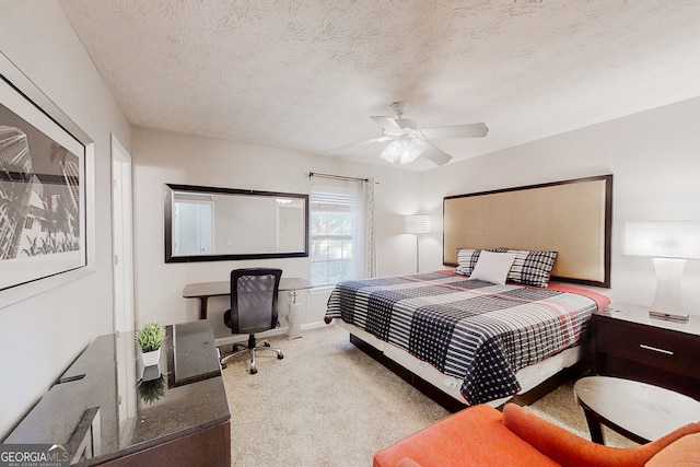 bedroom with ceiling fan, a textured ceiling, and light colored carpet