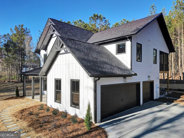 view of property exterior featuring driveway, a shingled roof, and board and batten siding