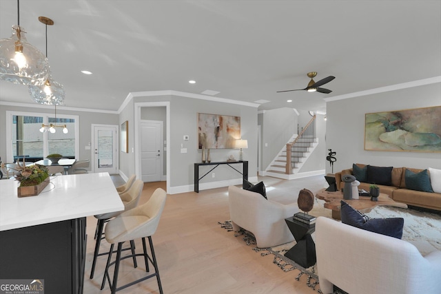 living room featuring light wood finished floors, stairway, recessed lighting, and crown molding