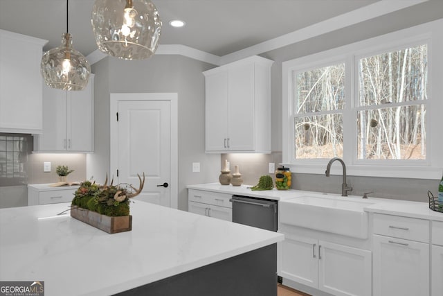 kitchen with hanging light fixtures, decorative backsplash, white cabinets, a sink, and dishwasher