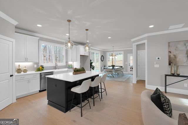 kitchen featuring a breakfast bar, white cabinetry, light countertops, light wood-type flooring, and dishwasher