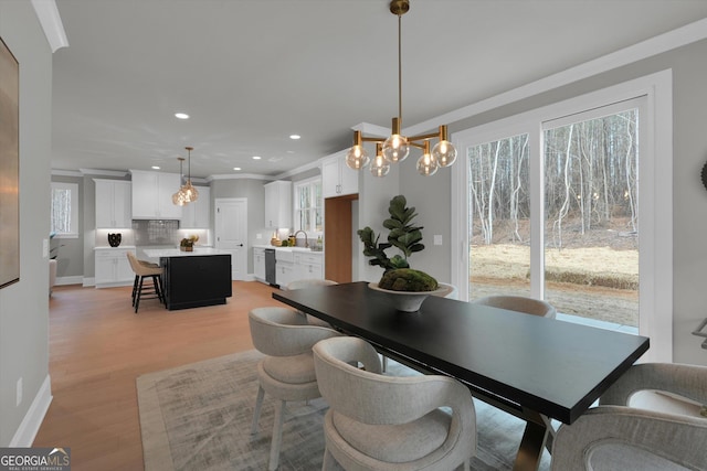 dining room featuring ornamental molding, light wood finished floors, baseboards, and recessed lighting