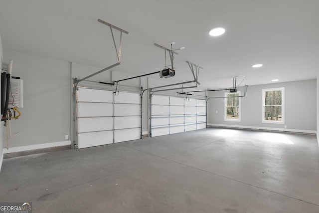 garage with a garage door opener, recessed lighting, and baseboards