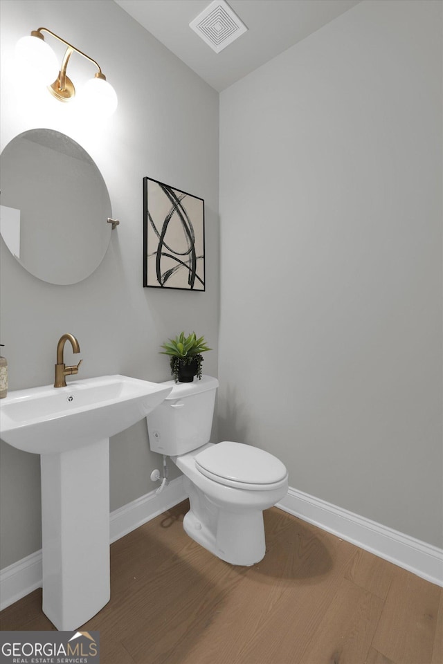 bathroom featuring visible vents, toilet, baseboards, and wood finished floors