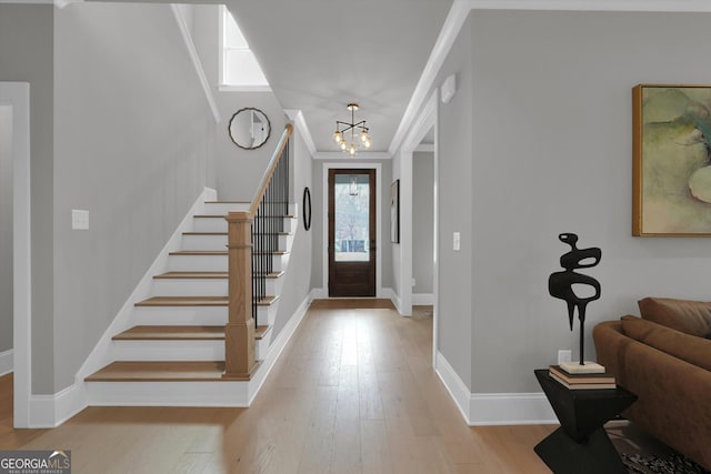 entryway featuring baseboards, stairway, wood finished floors, and ornamental molding