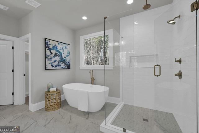 bathroom with a stall shower, baseboards, visible vents, marble finish floor, and a freestanding tub