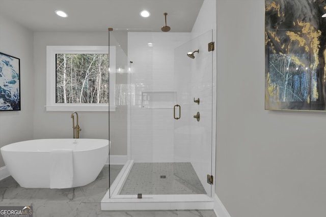 bathroom featuring recessed lighting, marble finish floor, a soaking tub, and a shower stall