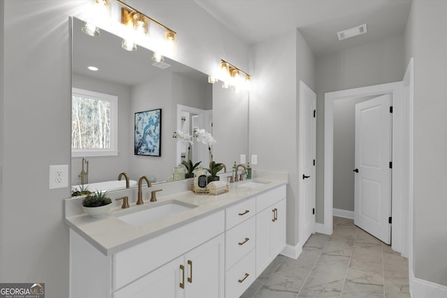 bathroom with marble finish floor, visible vents, a sink, and double vanity