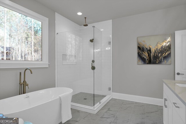 full bathroom with a freestanding tub, vanity, baseboards, marble finish floor, and a stall shower