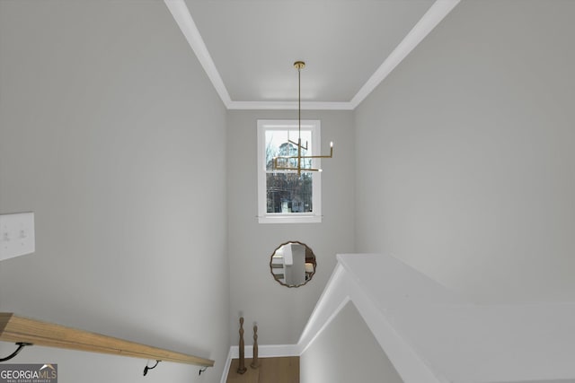 stairway with baseboards, crown molding, and wood finished floors