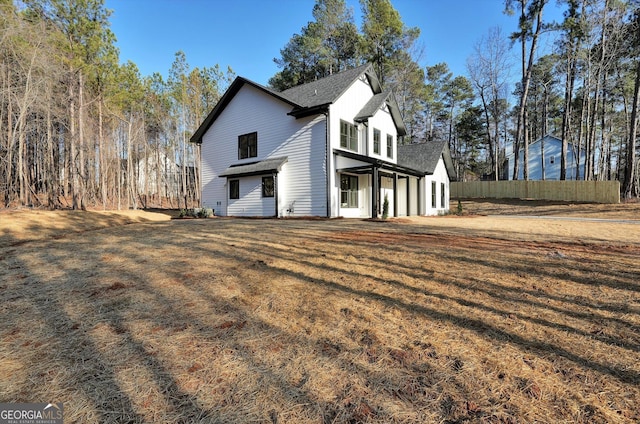 view of side of home featuring a yard and fence