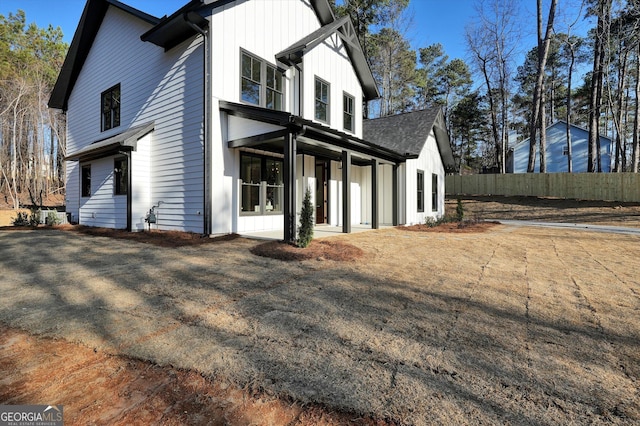 view of property exterior featuring board and batten siding and fence