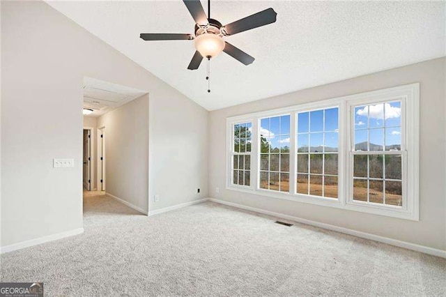 spare room featuring lofted ceiling, visible vents, light carpet, and baseboards