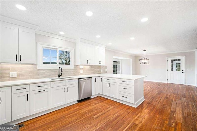 kitchen with white cabinetry, dishwasher, a peninsula, and a sink