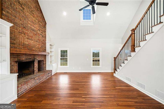 unfurnished living room featuring high vaulted ceiling, stairs, visible vents, and dark wood finished floors