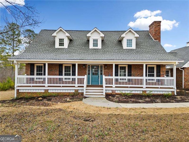 view of front of property with a porch, a front yard, and brick siding