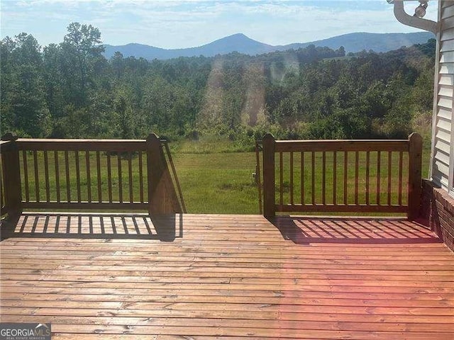 wooden terrace featuring a yard and a mountain view