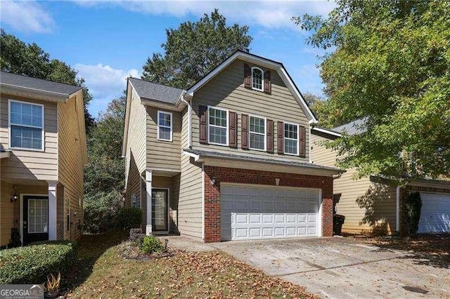 traditional-style house with a garage, concrete driveway, and brick siding