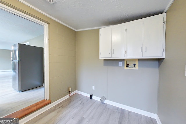 laundry area featuring hookup for a washing machine, cabinet space, light wood-style floors, and baseboards