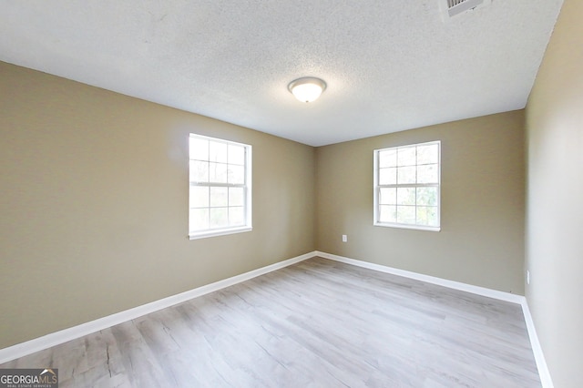 unfurnished room with a wealth of natural light, light wood-style flooring, and baseboards