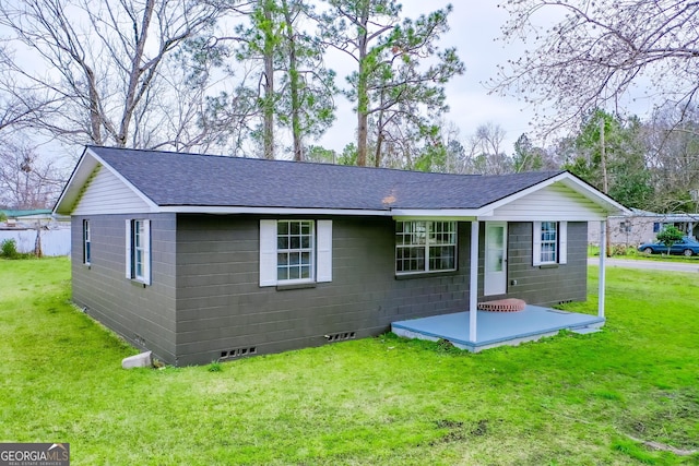 view of front of property with crawl space, roof with shingles, a front yard, and concrete block siding