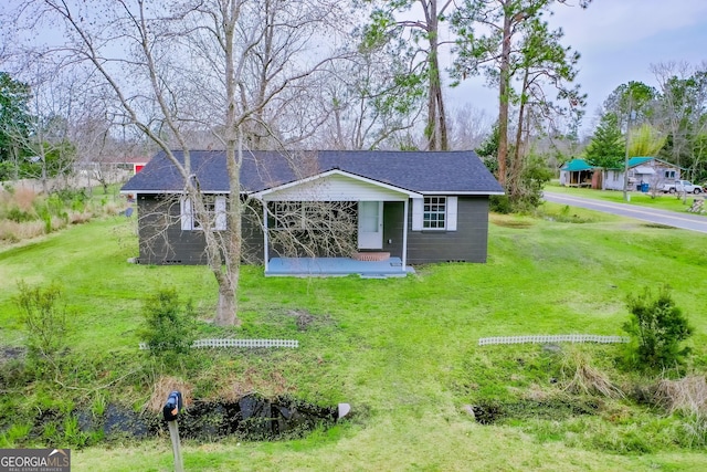 view of front of house featuring roof with shingles and a front lawn