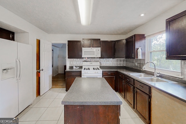 kitchen featuring white appliances, a center island, a sink, dark brown cabinets, and backsplash