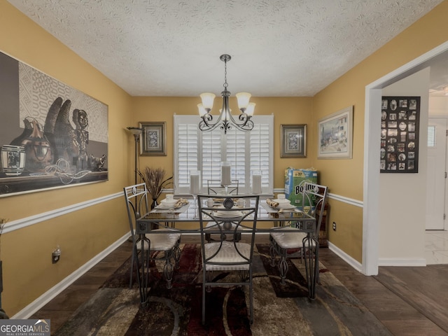 dining room featuring an inviting chandelier, baseboards, and wood finished floors