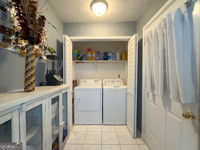 laundry area featuring laundry area, a textured ceiling, and independent washer and dryer