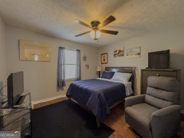 bedroom featuring baseboards, a textured ceiling, a ceiling fan, and wood finished floors