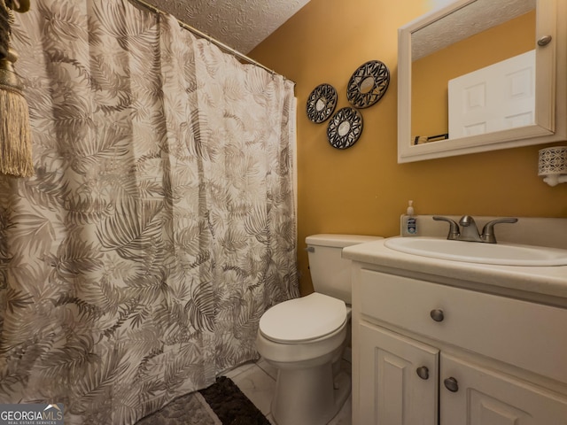 bathroom with a textured ceiling, marble finish floor, vanity, and toilet