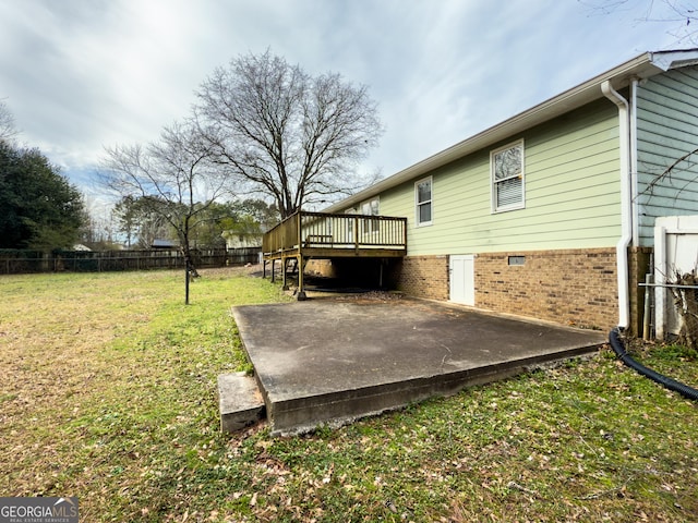 view of yard with fence, a deck, and a patio