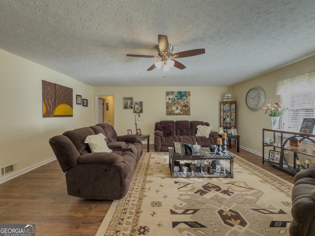 living area featuring ceiling fan, dark wood finished floors, visible vents, and baseboards