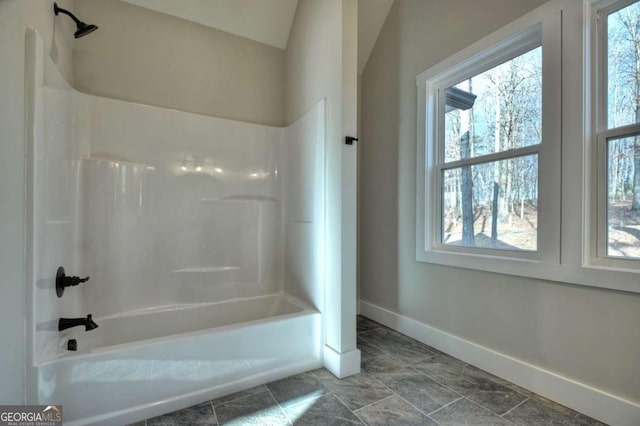 bathroom featuring shower / bathtub combination and baseboards