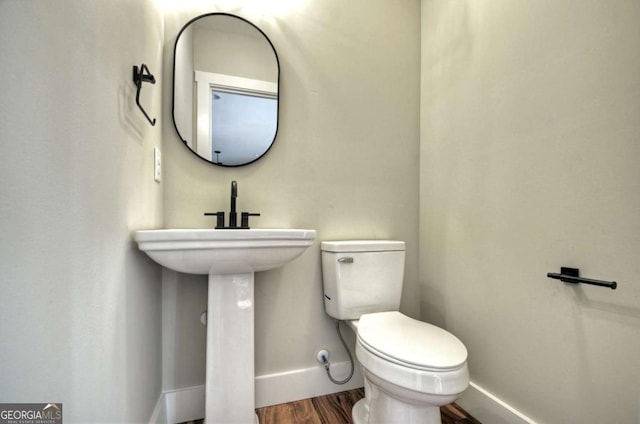 bathroom featuring wood finished floors, toilet, and baseboards