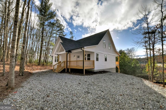 view of property exterior featuring a shingled roof and a wooden deck