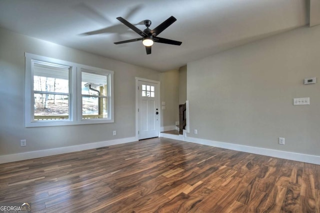 interior space featuring a ceiling fan, visible vents, dark wood finished floors, and baseboards