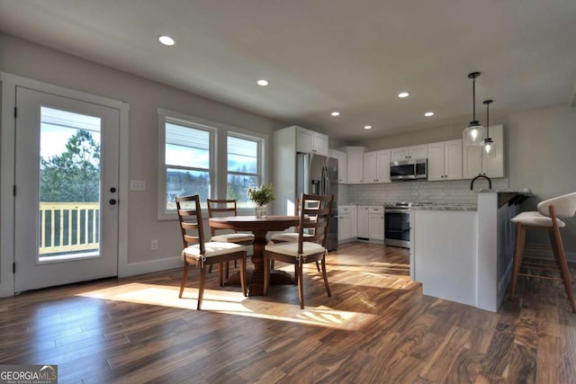 dining space with baseboards, dark wood-style flooring, and recessed lighting