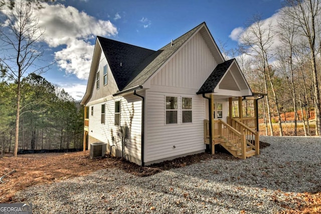 view of property exterior with a shingled roof, board and batten siding, and central air condition unit