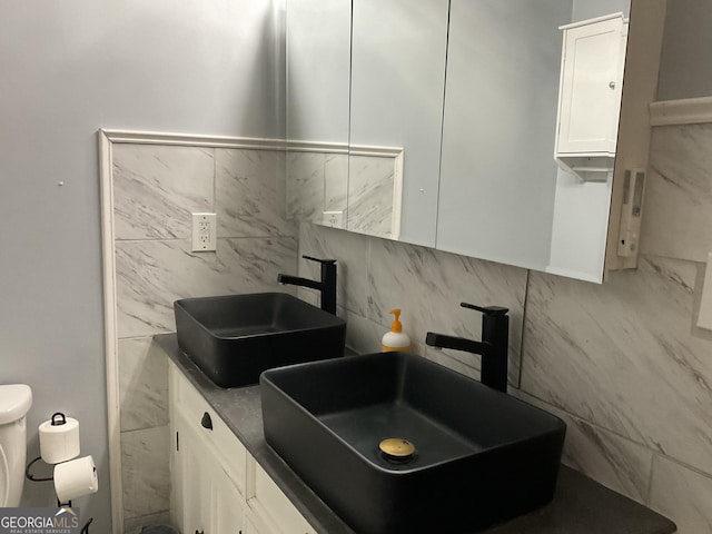 kitchen featuring dark countertops, a sink, white cabinetry, and electric panel