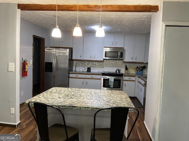 kitchen with dark wood-style floors, a center island, stainless steel appliances, decorative backsplash, and a kitchen bar