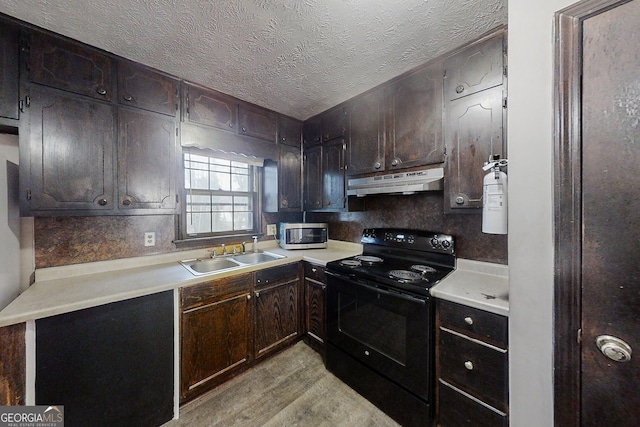 kitchen featuring under cabinet range hood, black range with electric stovetop, a sink, light countertops, and stainless steel microwave