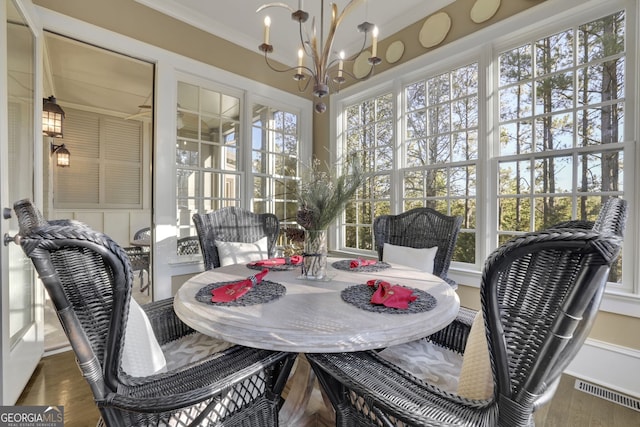 sunroom / solarium featuring an inviting chandelier and visible vents