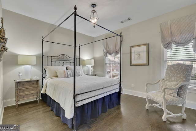 bedroom featuring dark wood-type flooring, visible vents, and baseboards