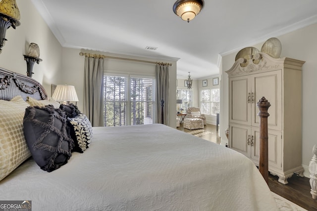 bedroom with baseboards, dark wood finished floors, visible vents, and crown molding