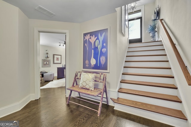 staircase with wood finished floors and visible vents